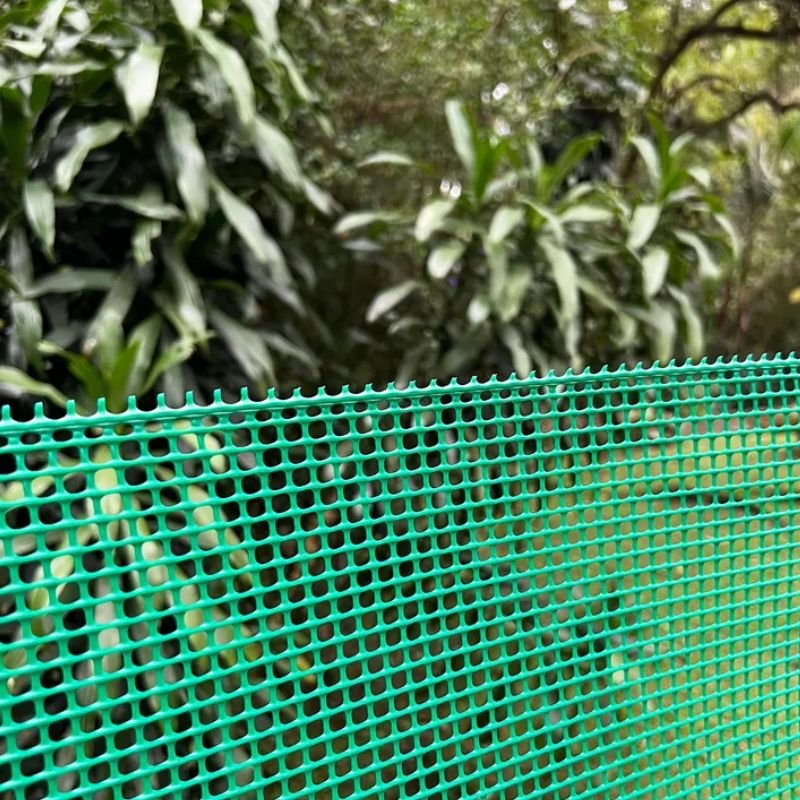 Malla cerca plástica verde en jardín